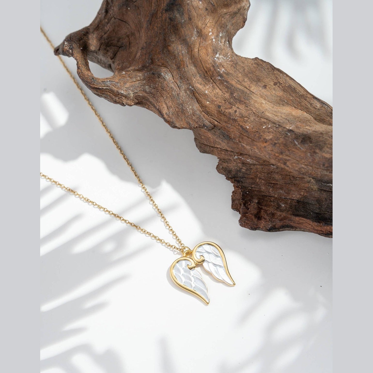 Änglavingar halsband i stål med pärlemorhjärta och himmelsk symbolik